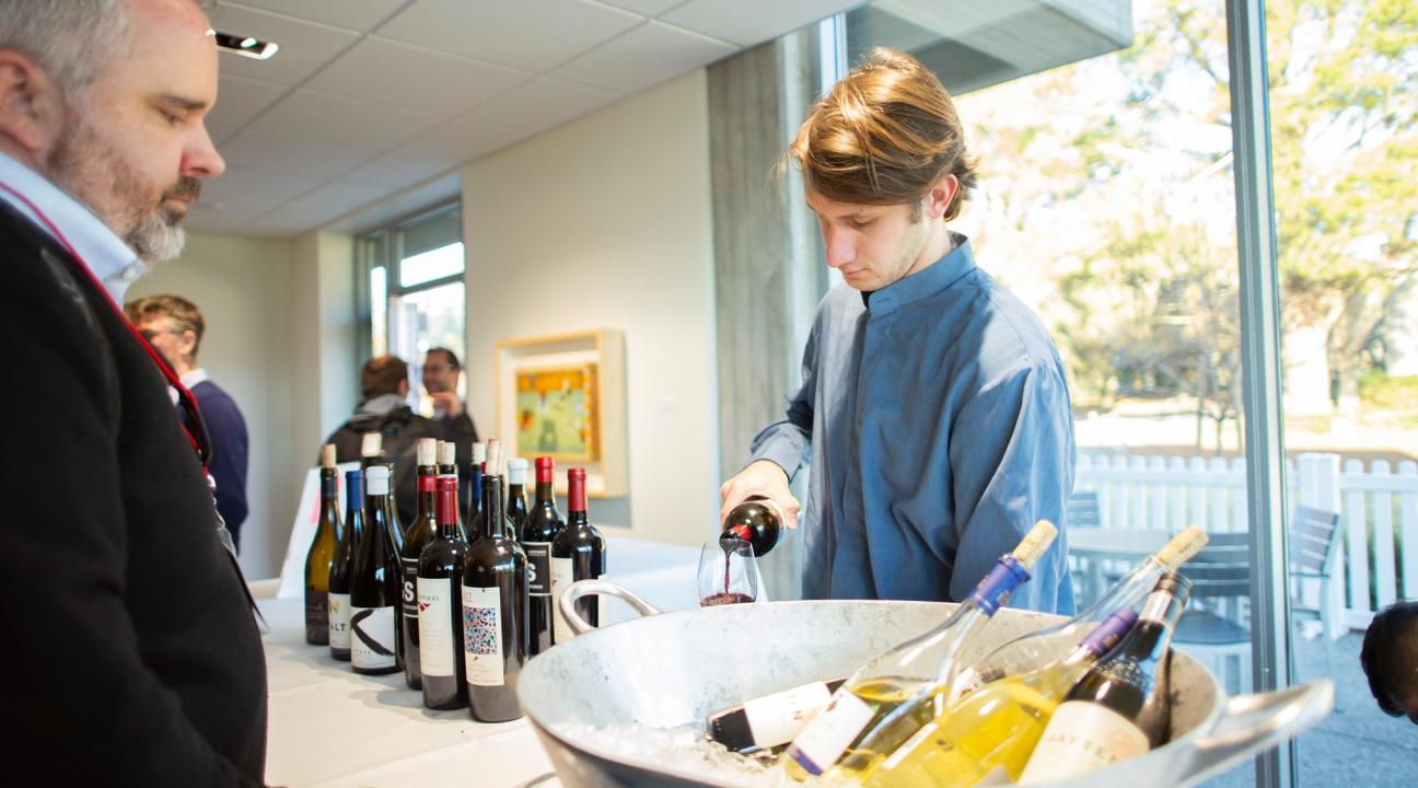 Catering staff member pouring a glass of wine 