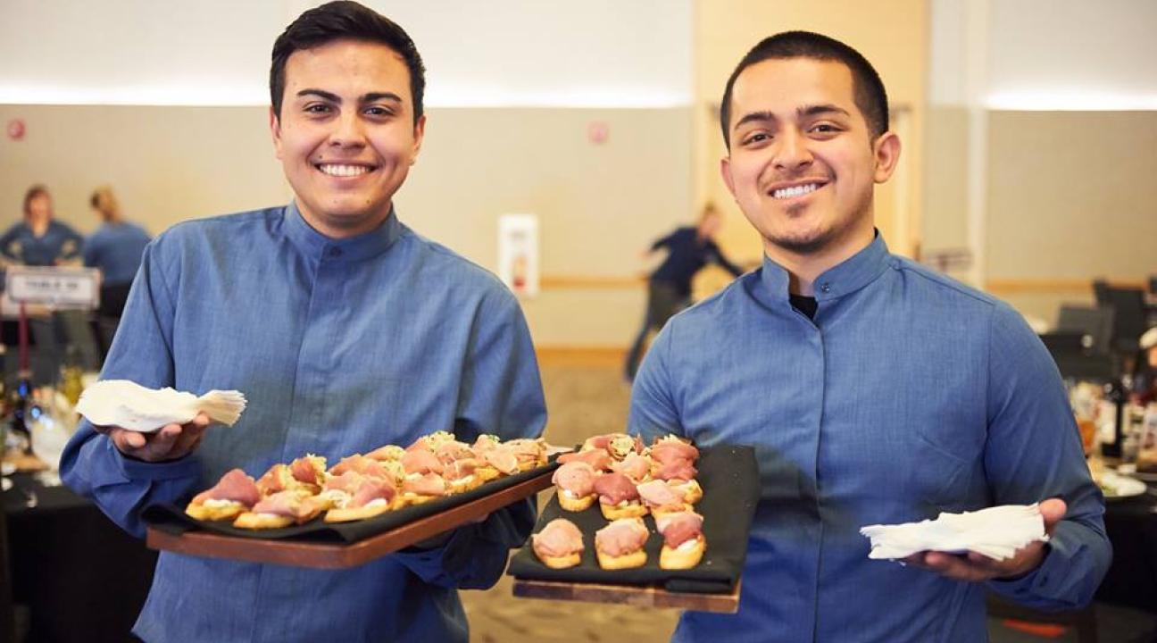 Two employees with trays of food 