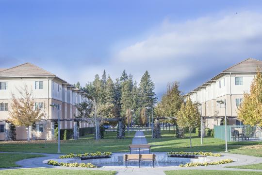 white buildings with a water feature and green grass