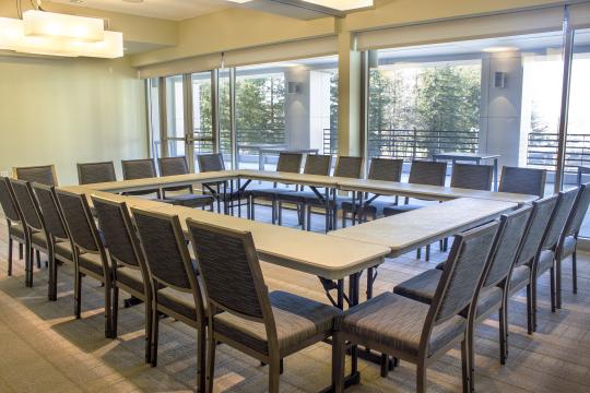 a room with a wall of windows and a square table