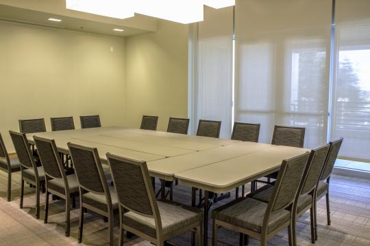 a room with a wall of windows and a square table