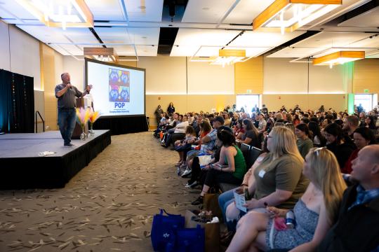 interior of conference and event space with a large crowd listening to a speaker