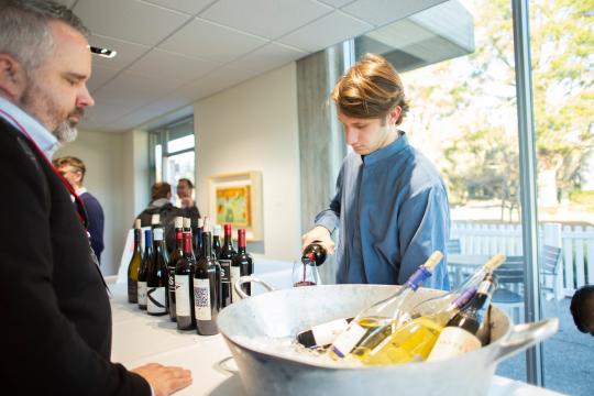 Catering staff member pouring a glass of wine 