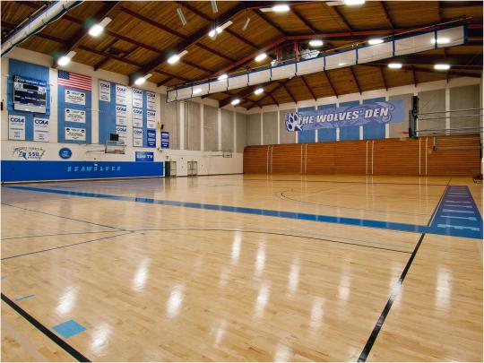 a gym interior with a blue sign that says wolves den