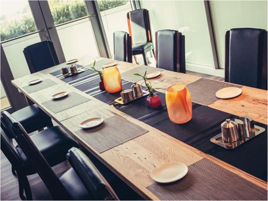 an elegant wooden dining table with place settings