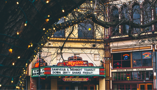 exterior of the mystic theater with tree branches in foreground