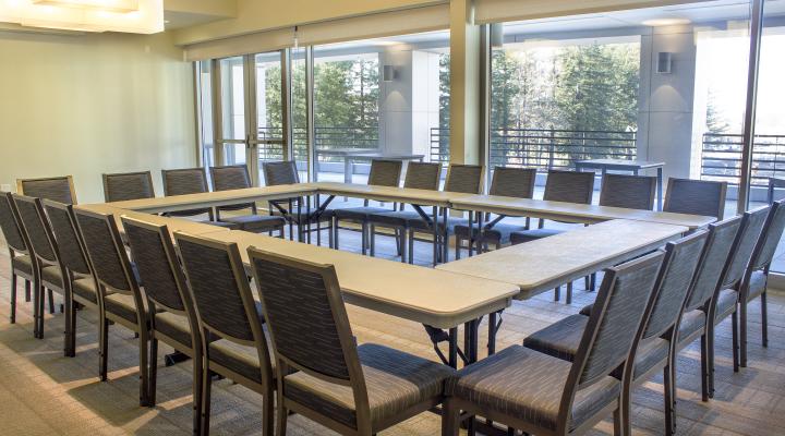 a room with a wall of windows and a square table