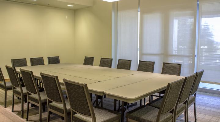 a room with a wall of windows and a square table