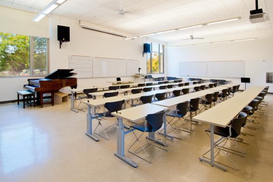 a bright, airy interior of a classroom space with white walls and large windows